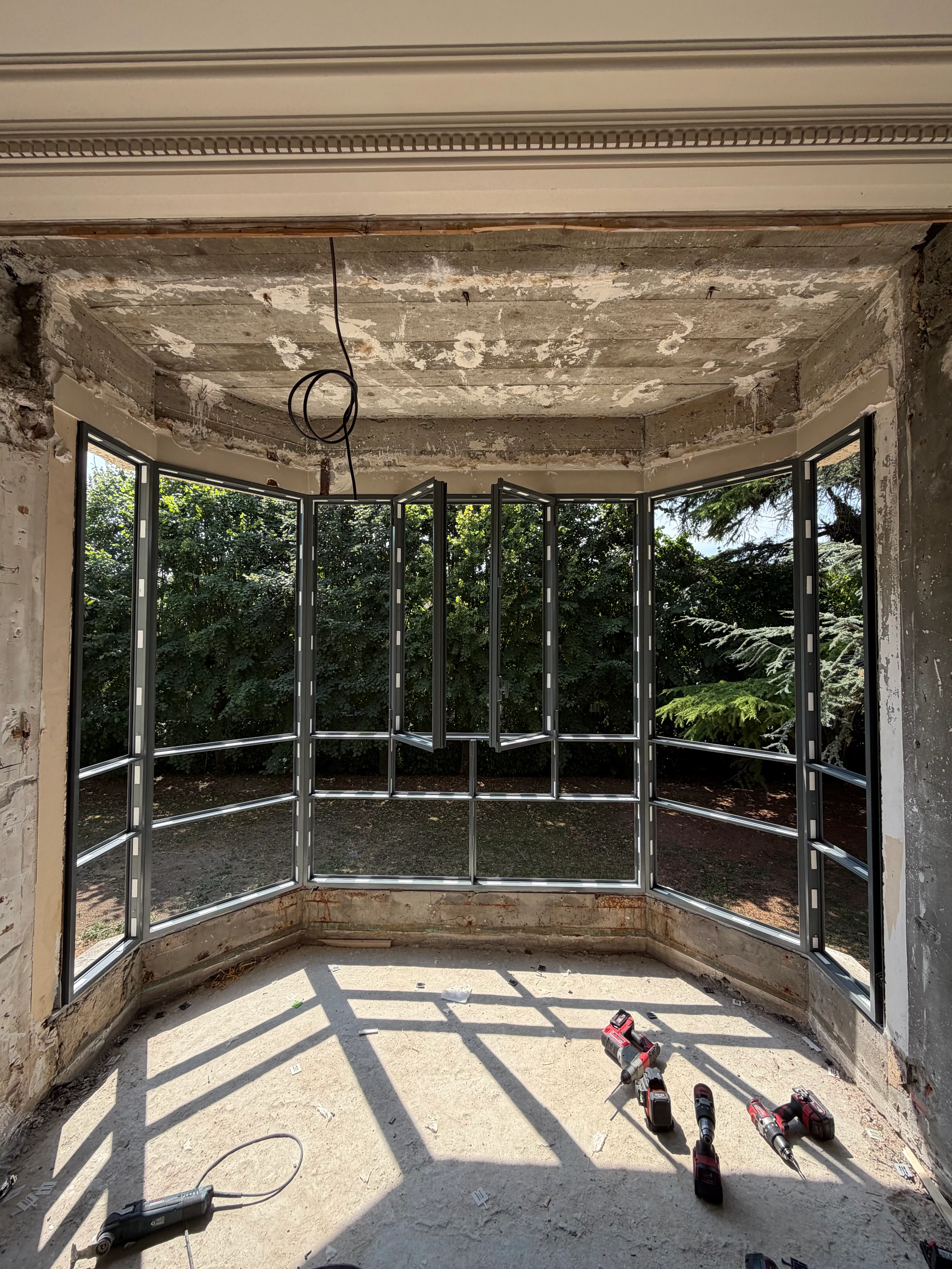 Structure en aluminium du nouveau bow window en cours de montage dans l'ouverture