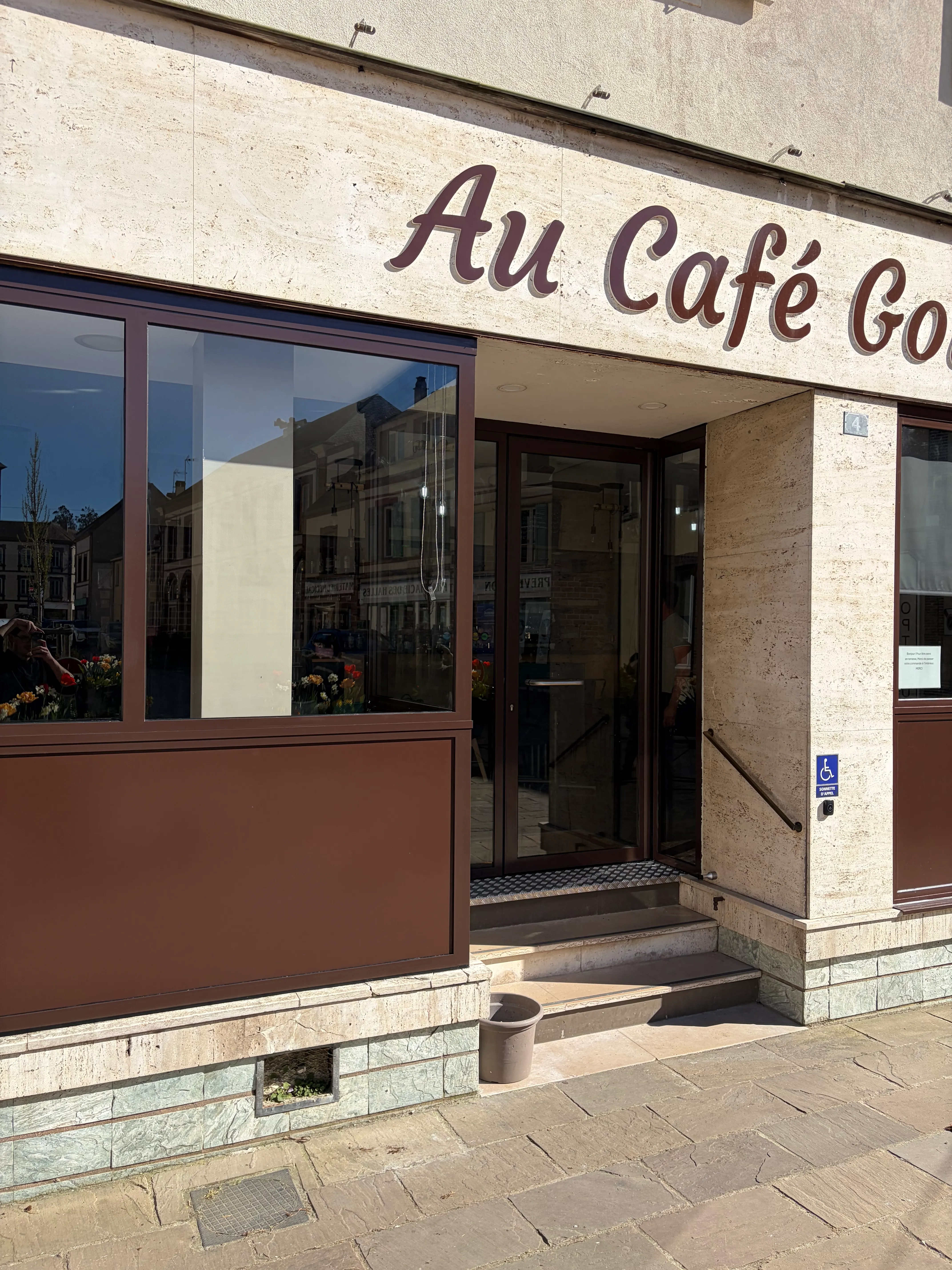 Gros plan en biais sur l'angle de la vitrine en acier et aluminium marron, mettant en évidence la précision des assemblages soudés et l'ajustement du vitrage.