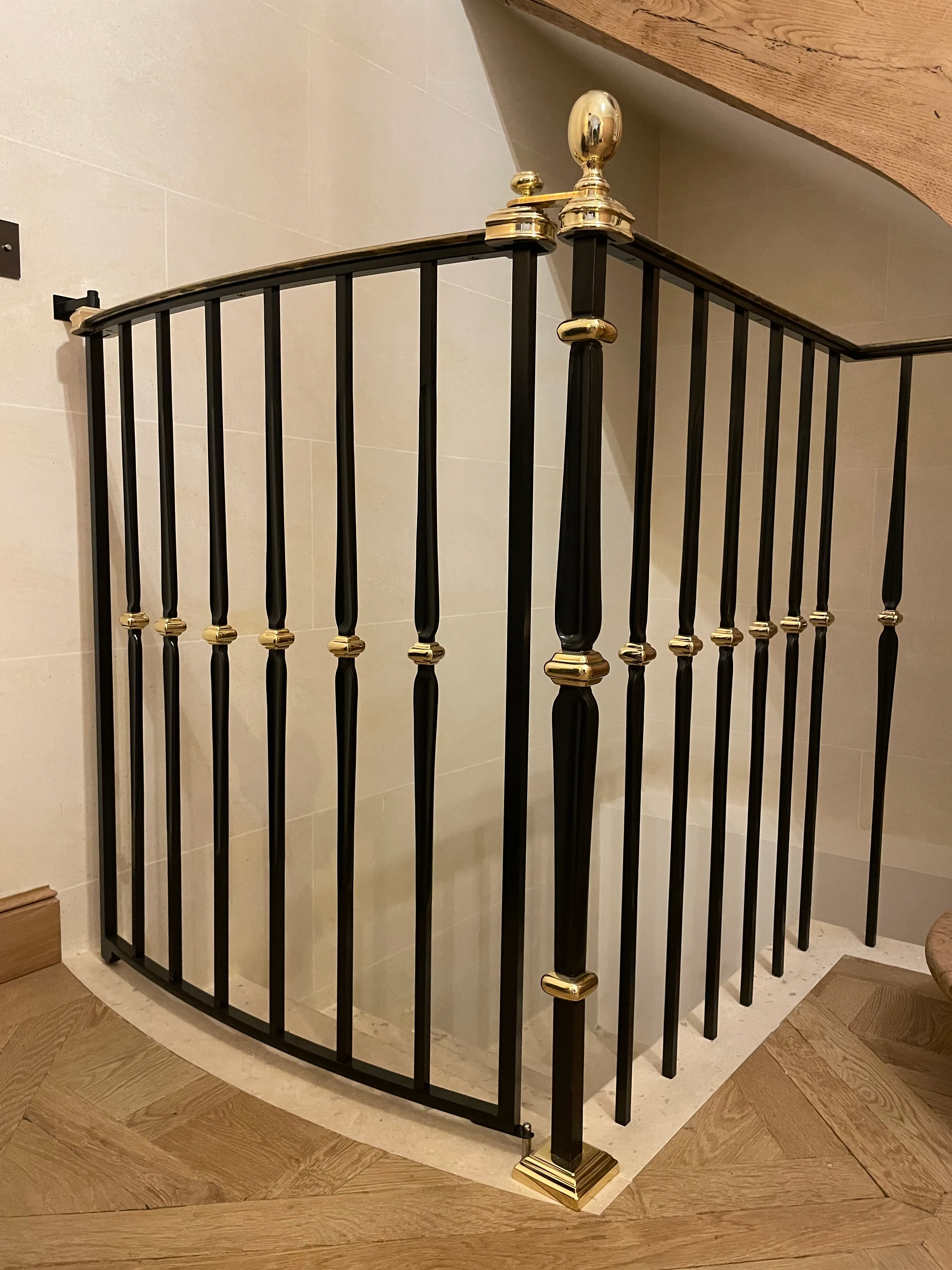 Poteau de départ et fermeture en laiton pour barrière d'escalier sur mesure Gros plan sur le poteau de départ et les finitions en laiton d'un barreaudage en acier assemblé mécaniquement sans soudure.